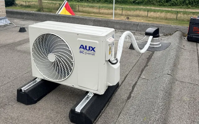 Buitenunit van een airconditioningsysteem netjes gemonteerd aan een woning